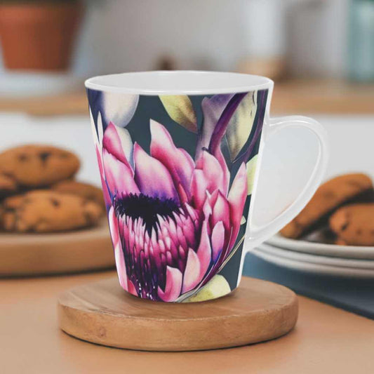 Bright Floral patterned ceramic Latte Mug with c shaped handle 12oz - scratch resistant 'Africa Blooms' Latte Mug, 12oz - Free Shipping in Canada. Pictured on a coaster on a white kitchen counter with plates of ginger cookies on either side