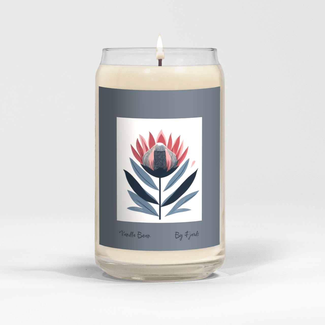 Vanilla Bean Scent Candle 13,75 ounce Soy Wax. Burns for 60 hours or more. Image of a stylized graphic protea flower in blue ans salmon pink with a slate blue border. The Words 'Vanilla Bean' and 'Fjarils' are on the bottom of the label under the image.