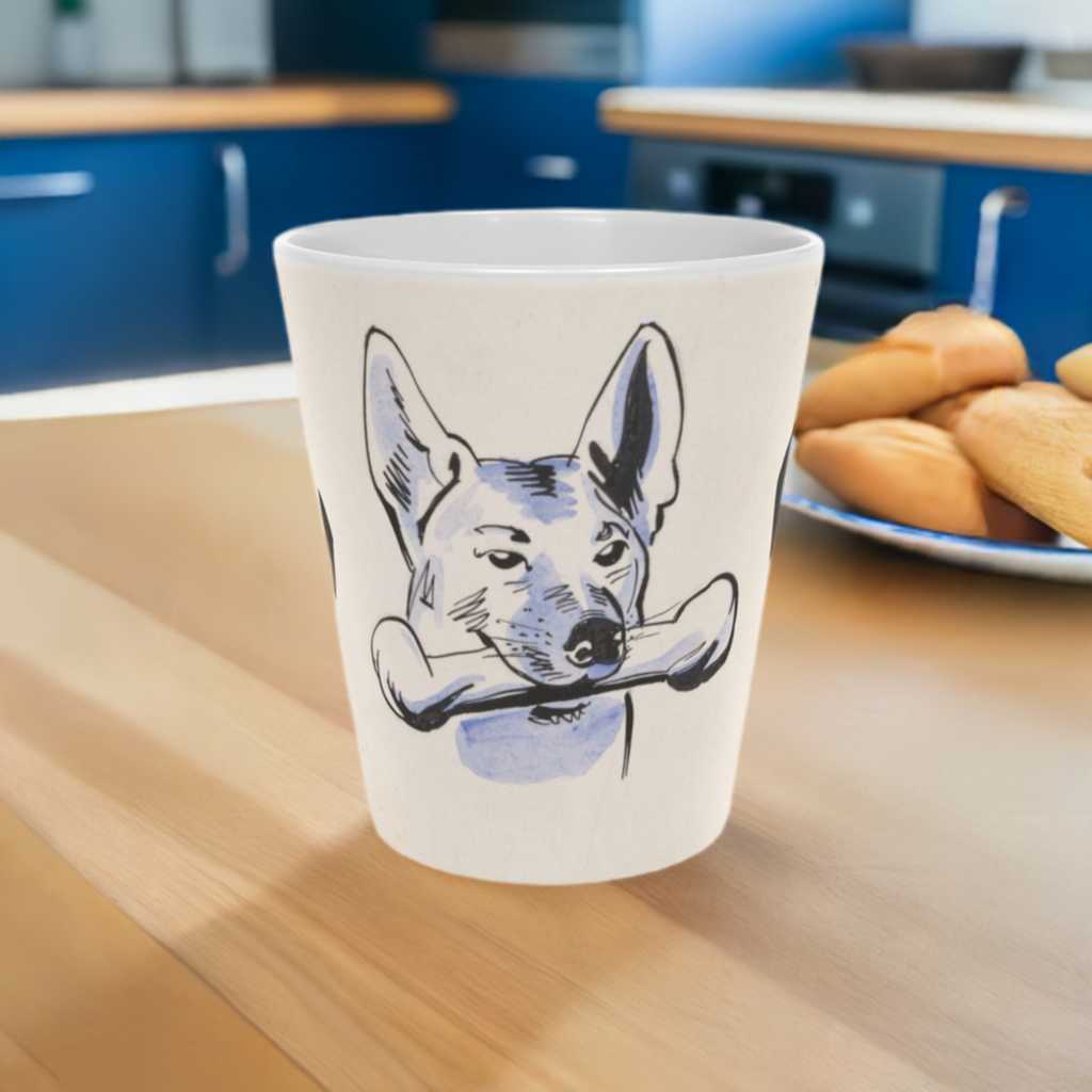 'Dog and Bone' scratch resistant  ceramic Latte Mug with c shaped handle 12oz - scratch resistant 'Cycling' Latte Mug, 12oz - Free shipping in Canada.   in a bue and white illustration depicting a dog with a bone in his mouth illustration.  Pictured on a wooden kitchen countertop with blue cabinets in the background and a plate of cookies to the right of the mug